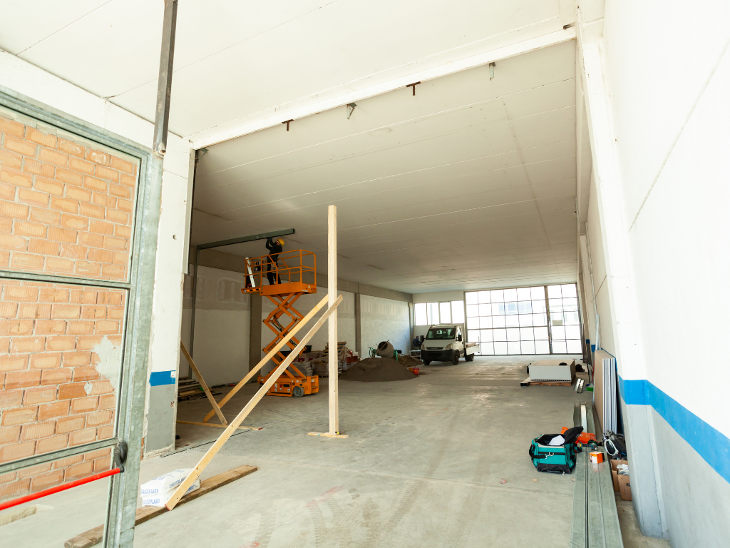 Worker on a scissor lift inside a building under construction.